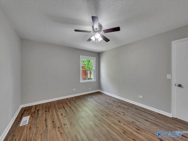 1419 11th St SE, Cullman, AL 35055 - spare room featuring visible vents, wood finished floors, baseboards, ceiling fan, and a textured ceiling