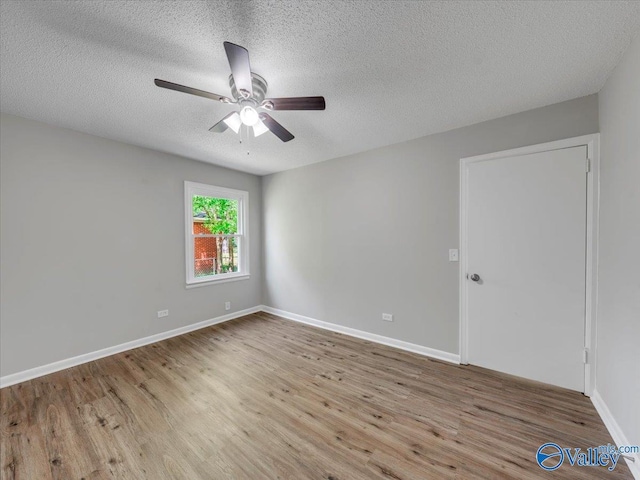 1419 11th St SE, Cullman, AL 35055 - spare room featuring baseboards, a ceiling fan, a textured ceiling, and wood finished floors