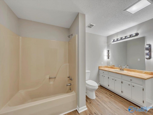1419 11th St SE, Cullman, AL 35055 - bathroom featuring visible vents, wood finished floors, vanity, toilet, and washtub / shower combination