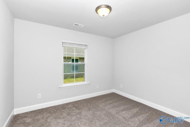 empty room featuring carpet, visible vents, and baseboards