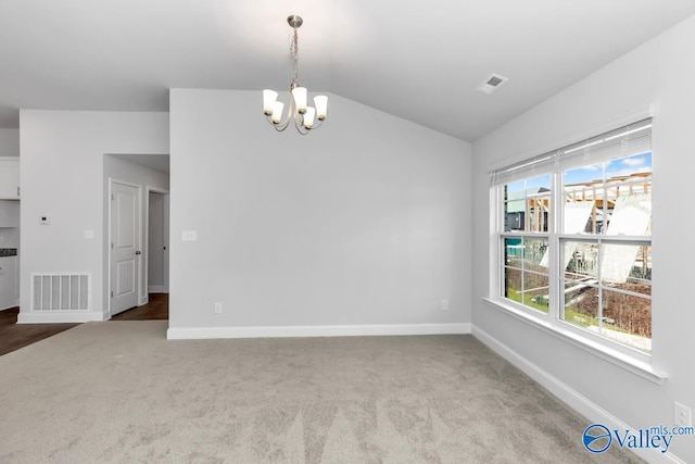 carpeted empty room featuring lofted ceiling, an inviting chandelier, baseboards, and visible vents