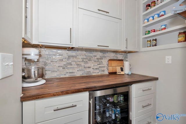 bar featuring beverage cooler, backsplash, and a dry bar