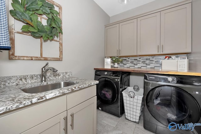 washroom featuring cabinet space, a sink, and separate washer and dryer