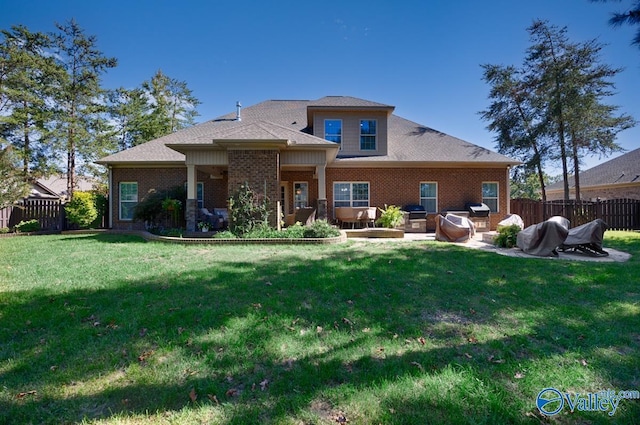 back of house featuring a patio, fence, a lawn, and brick siding