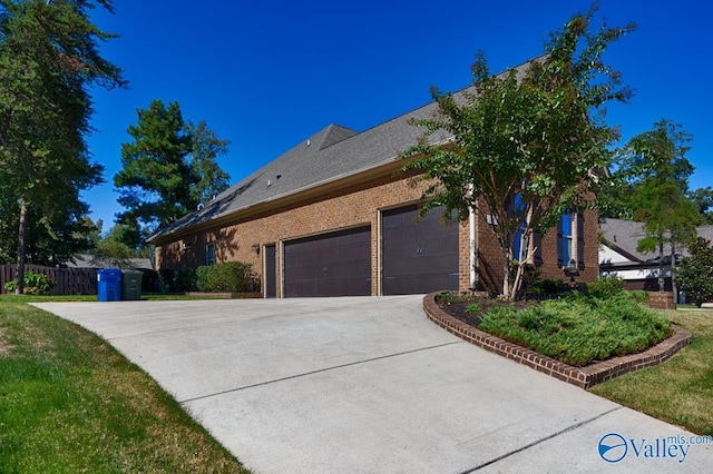 view of property exterior featuring a garage, driveway, brick siding, and fence