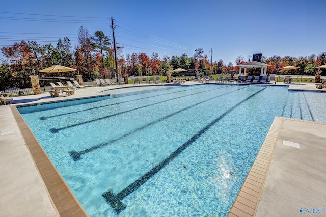 pool featuring a gazebo, a patio, and fence