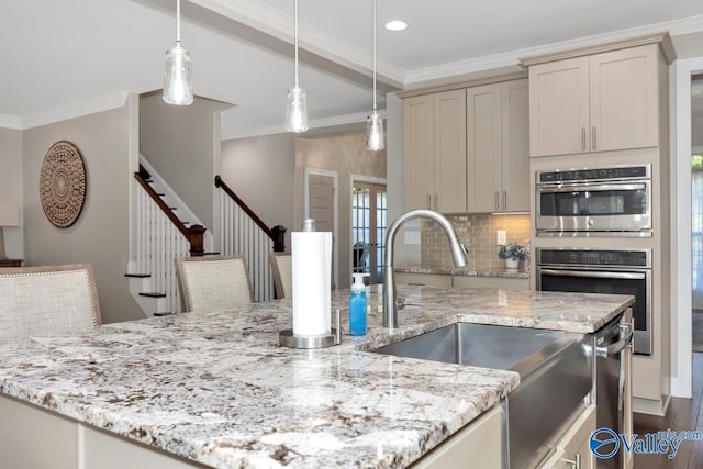 kitchen featuring tasteful backsplash, ornamental molding, light stone countertops, stainless steel double oven, and a sink