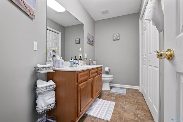 bathroom featuring visible vents, toilet, tile patterned flooring, baseboards, and vanity