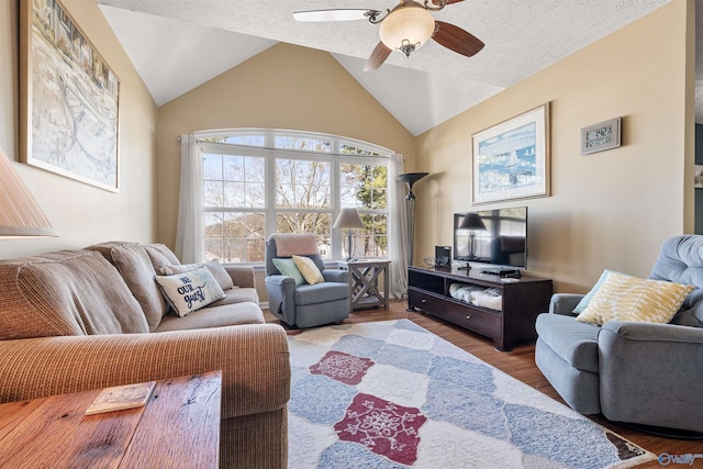 living room featuring ceiling fan, a textured ceiling, wood finished floors, and vaulted ceiling