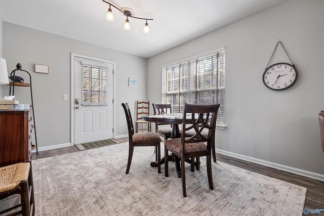 dining room with baseboards, plenty of natural light, and wood finished floors