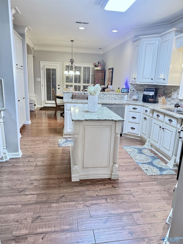 3205 Germantown Pl, Decatur, AL 35603 - kitchen with a peninsula, dishwasher, wood finished floors, ornamental molding, and hanging light fixtures