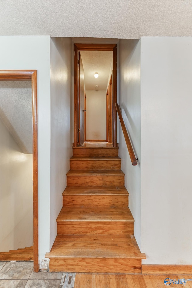 staircase with a textured ceiling