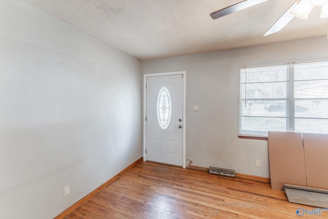 entrance foyer with ceiling fan, a textured ceiling, and light hardwood / wood-style flooring