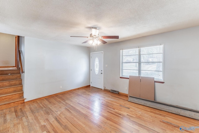 interior space featuring ceiling fan, light hardwood / wood-style floors, and a textured ceiling