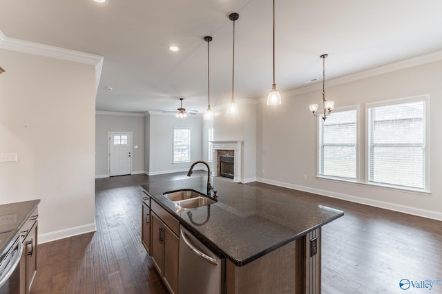 kitchen with dishwasher, an island with sink, sink, hanging light fixtures, and ornamental molding