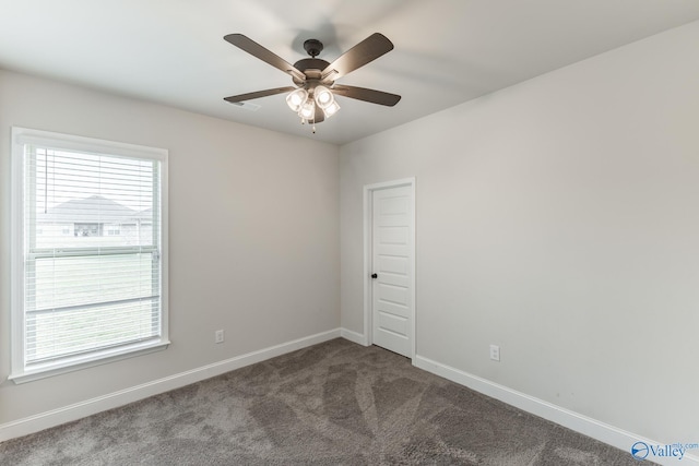 unfurnished room with a wealth of natural light, ceiling fan, and carpet