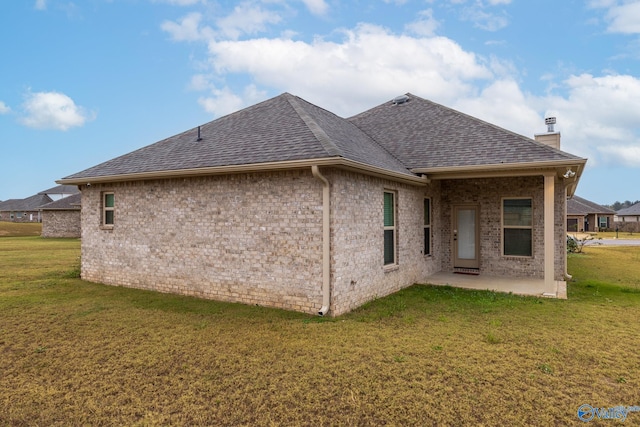 rear view of property featuring a yard and a patio