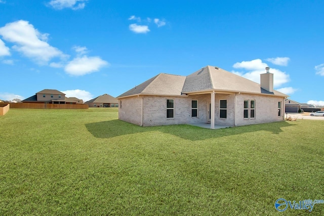 rear view of property featuring a yard