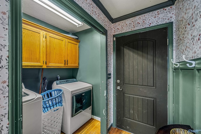 laundry room with separate washer and dryer, light hardwood / wood-style flooring, and crown molding