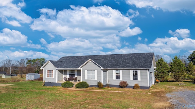 ranch-style home with covered porch, a storage shed, and a front lawn