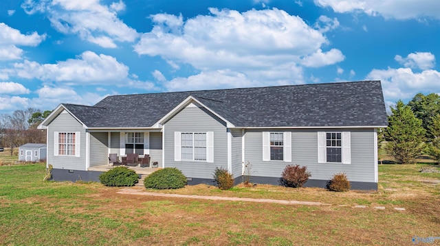 ranch-style home with a patio area, a front lawn, and a storage shed