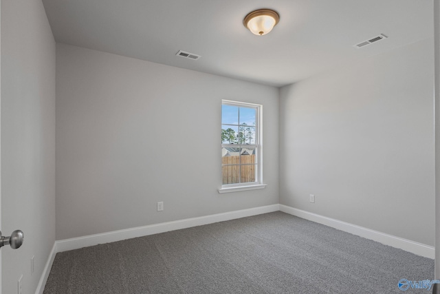 carpeted spare room with visible vents and baseboards