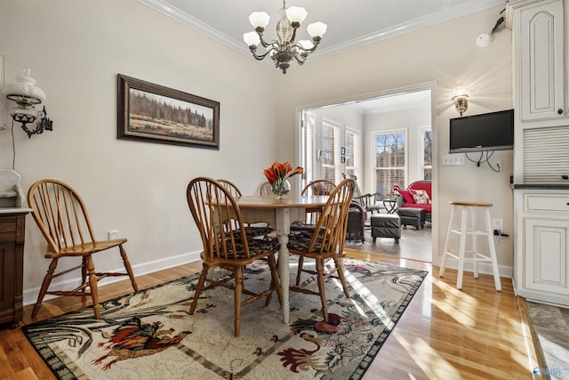 dining area with ornamental molding, a chandelier, and light hardwood / wood-style floors