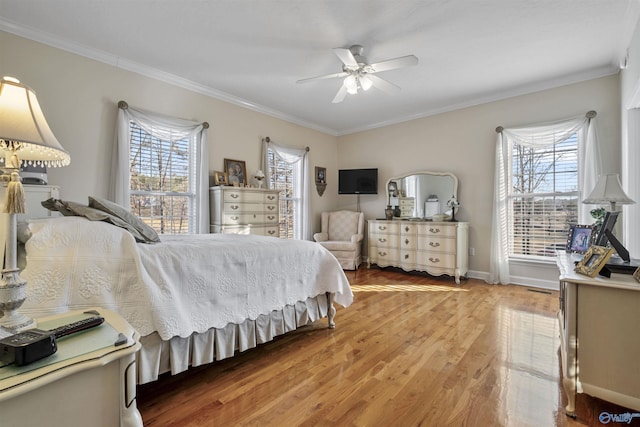 bedroom featuring hardwood / wood-style flooring, ornamental molding, ceiling fan, and multiple windows