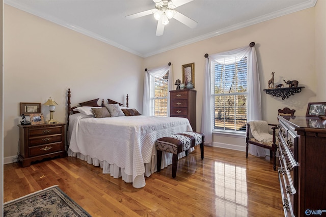 bedroom with hardwood / wood-style flooring, crown molding, and ceiling fan