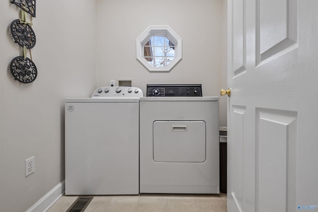 laundry room with light tile patterned flooring and washer and dryer