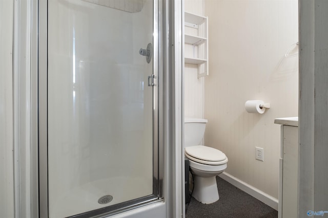 bathroom featuring a shower with door and toilet