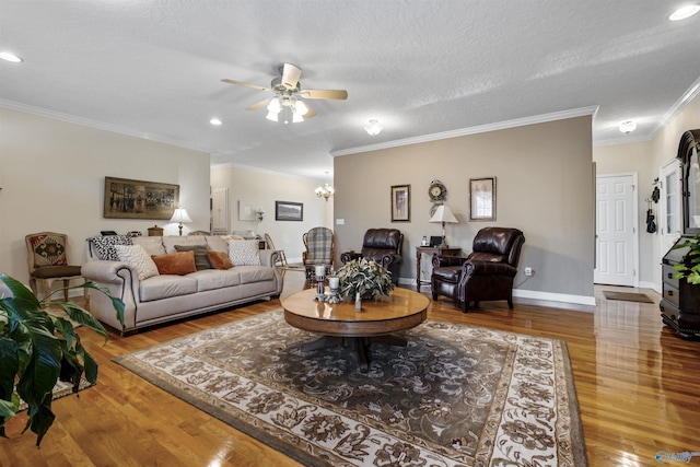 living room with crown molding, ceiling fan with notable chandelier, hardwood / wood-style floors, and a textured ceiling