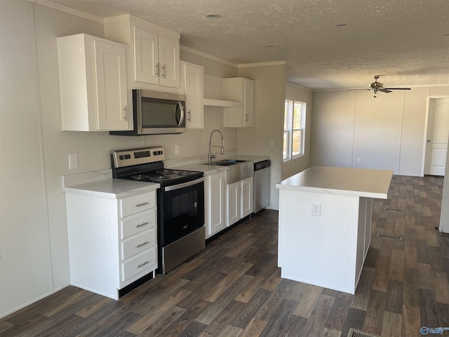 kitchen with a sink, a ceiling fan, dark wood finished floors, a textured ceiling, and stainless steel appliances
