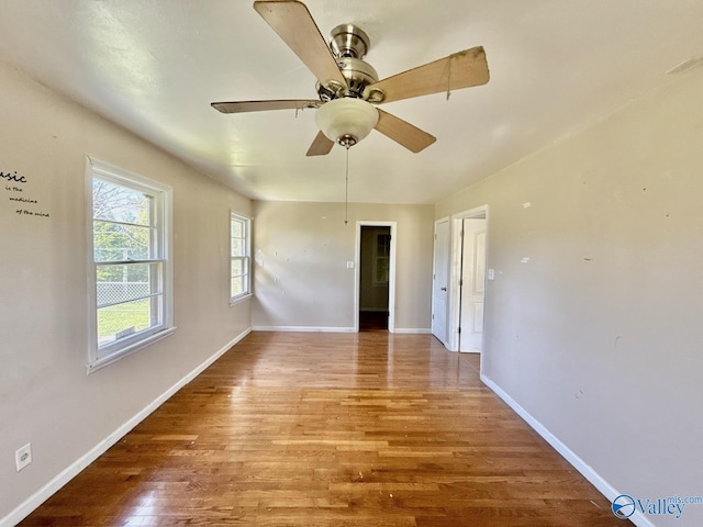 unfurnished room featuring baseboards, a ceiling fan, and wood finished floors
