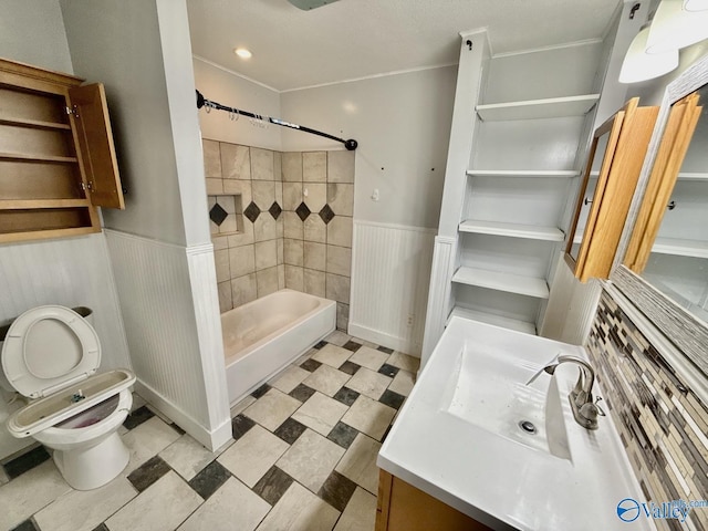 bathroom with toilet, a wainscoted wall, vanity, shower / bath combination, and tile patterned floors