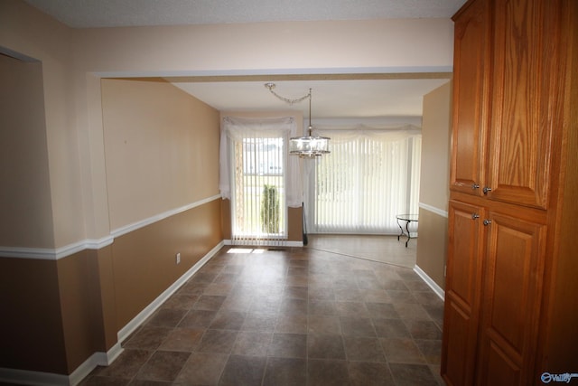 unfurnished dining area featuring an inviting chandelier