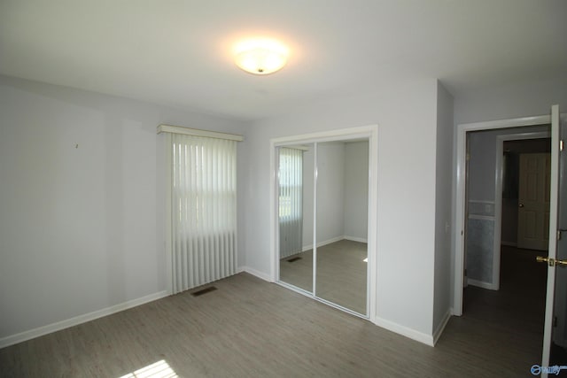 unfurnished bedroom with a closet and hardwood / wood-style floors