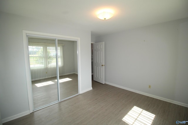 unfurnished bedroom featuring dark hardwood / wood-style floors and a closet