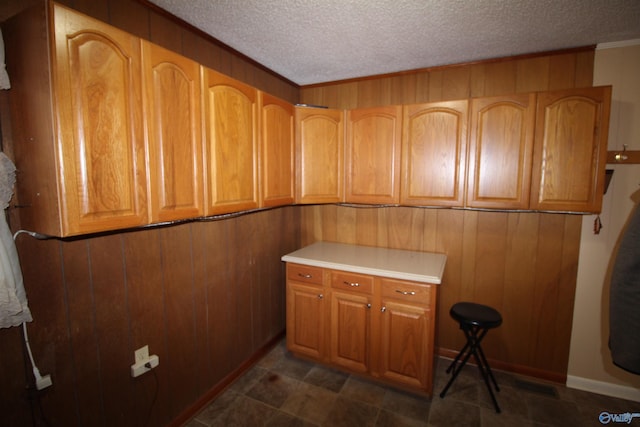 laundry room with wood walls and a textured ceiling