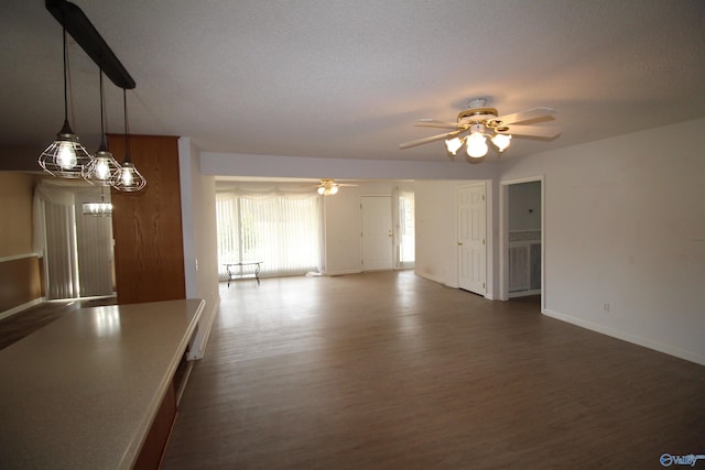 unfurnished living room featuring ceiling fan and dark hardwood / wood-style flooring