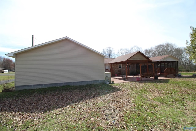 view of property exterior featuring a patio and a lawn