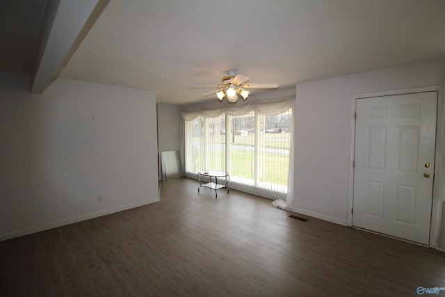 unfurnished living room featuring ceiling fan and dark hardwood / wood-style floors