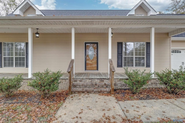 doorway to property featuring covered porch and a garage