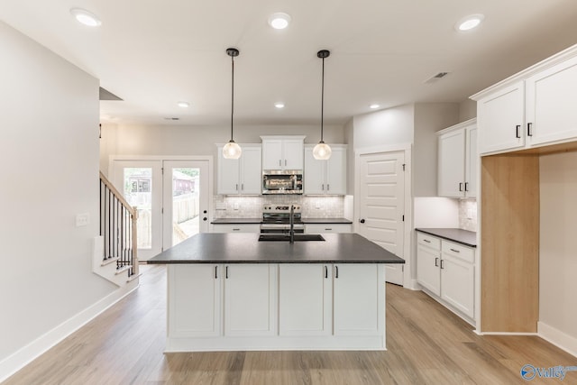 1201 Halsey Ave, Huntsville, AL 35801 - kitchen with stainless steel appliances, dark countertops, backsplash, light wood-style floors, and white cabinetry