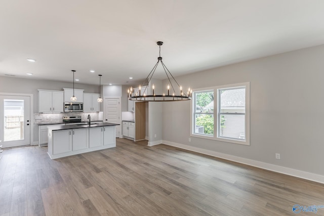1201 Halsey Ave, Huntsville, AL 35801 - kitchen with appliances with stainless steel finishes, a sink, dark countertops, backsplash, and a chandelier