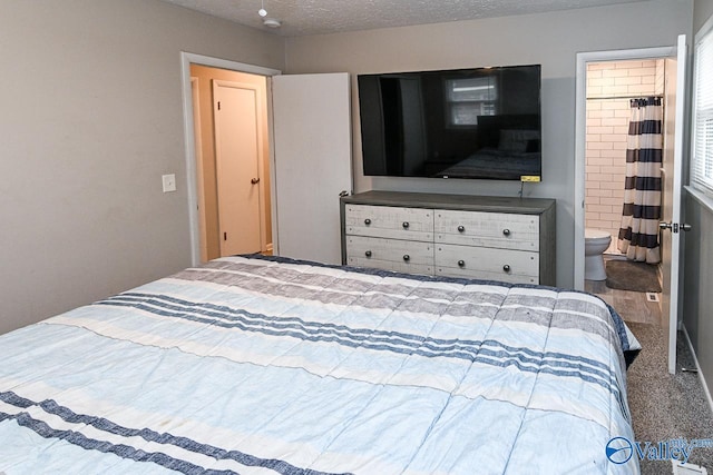 bedroom featuring connected bathroom, a textured ceiling, and carpet flooring