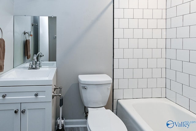 full bathroom featuring tiled shower / bath combo, vanity, and toilet