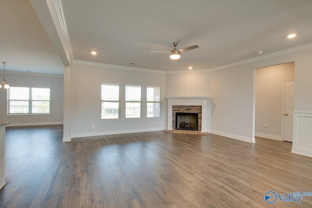 unfurnished living room featuring crown molding, ceiling fan, hardwood / wood-style flooring, and a fireplace