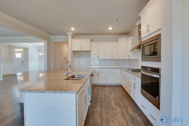 kitchen with a kitchen island with sink, appliances with stainless steel finishes, white cabinetry, and sink