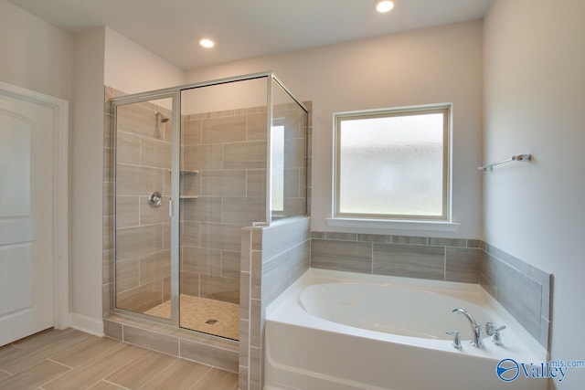 bathroom featuring shower with separate bathtub